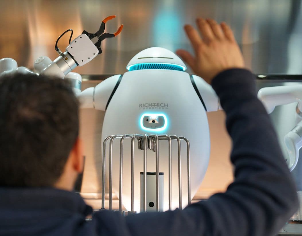 human waving to adam robot